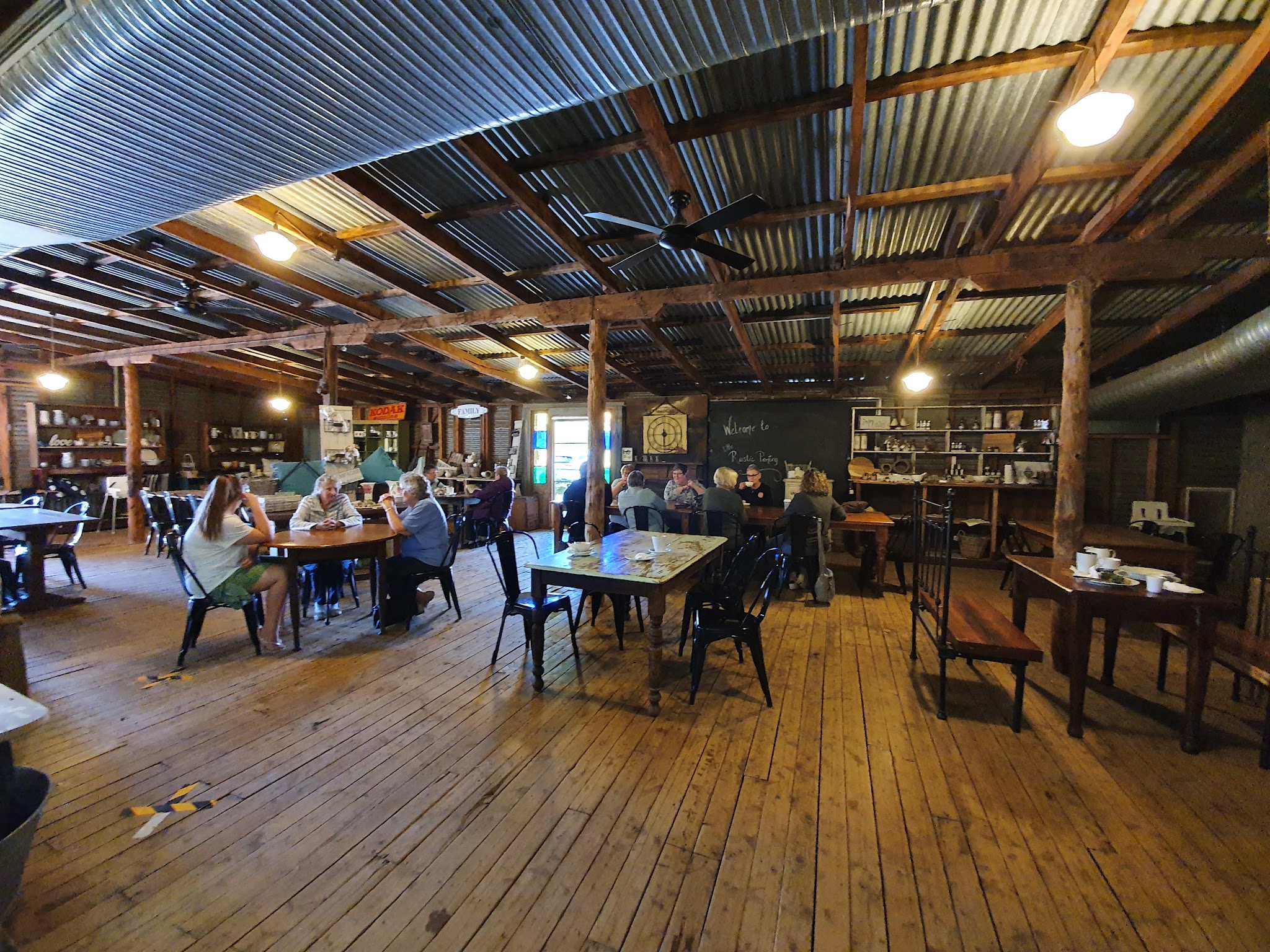 The main dining room with timber beams, corrugated iron roof and antique dressers
