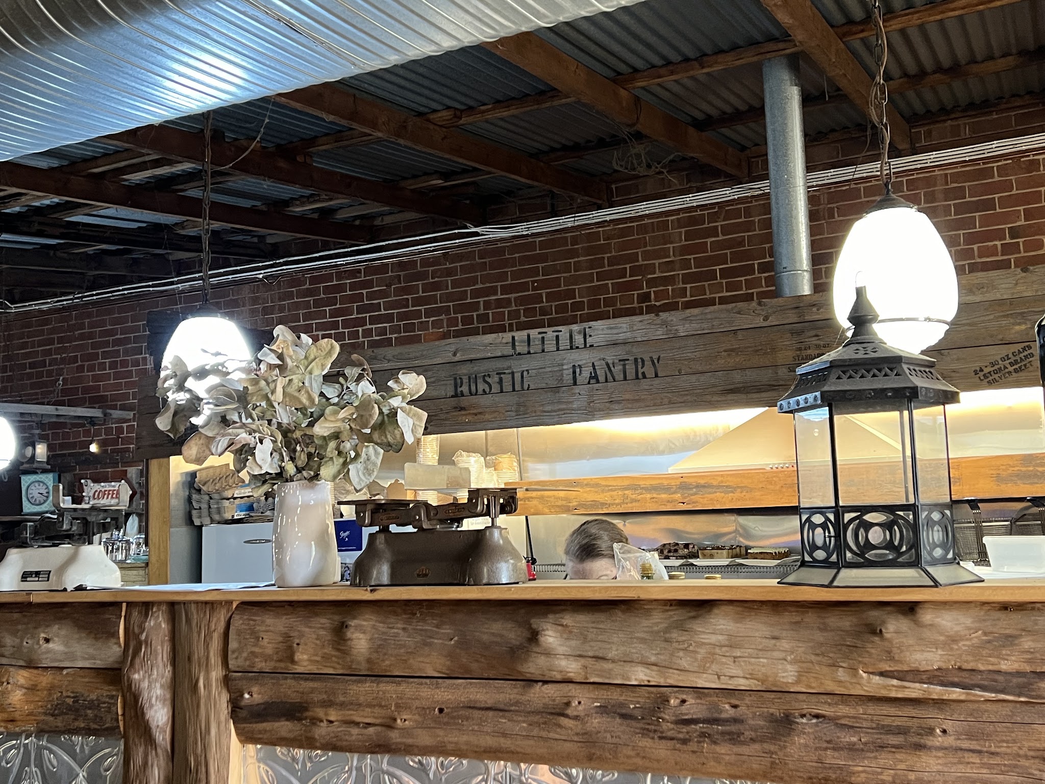 The counter with the stencilled Little Rustic Pantry timber beam, pendant lanterns and old scales