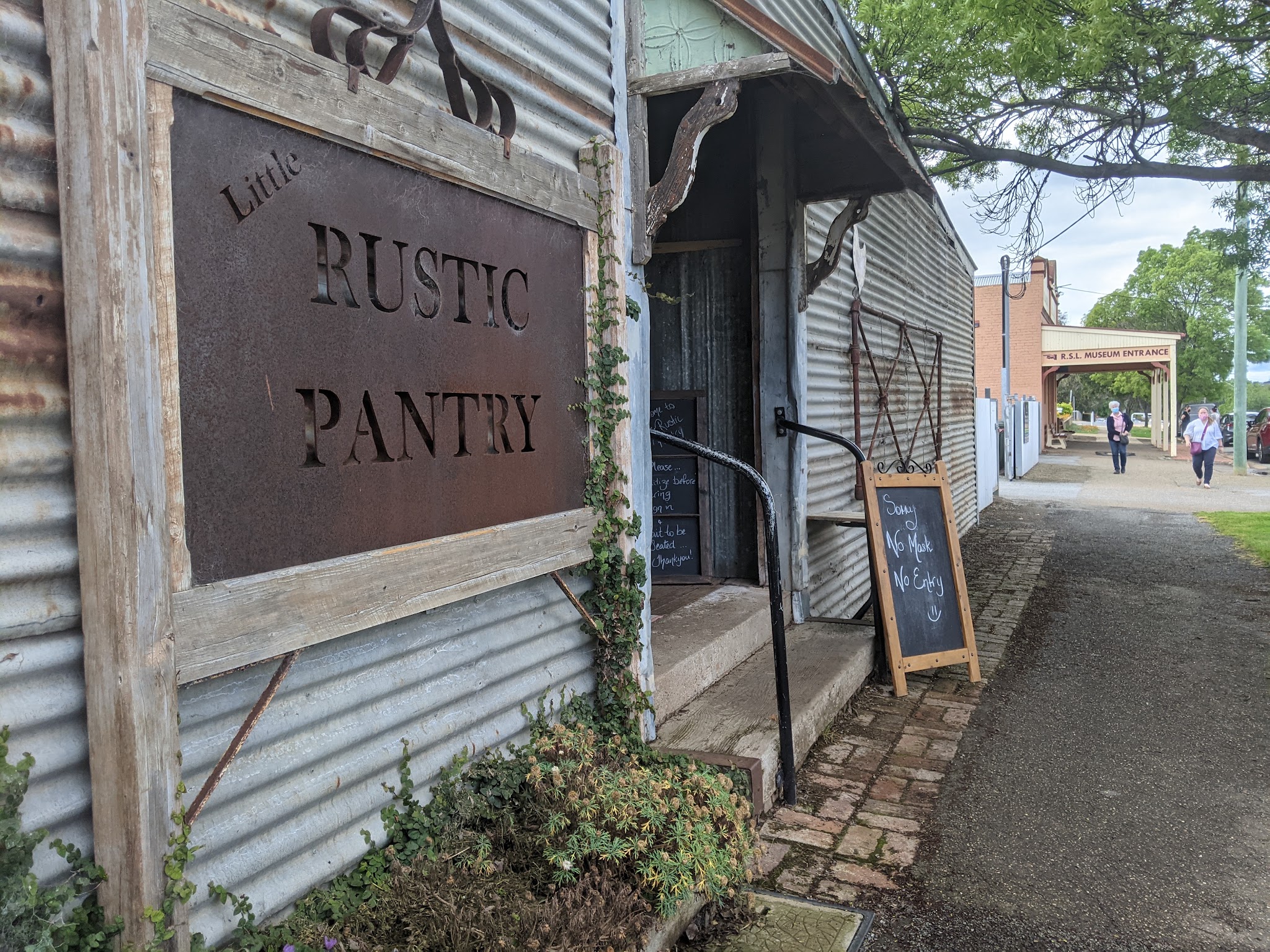 The laser-cut rusted Little Rustic Pantry sign on the corrugated-iron shopfront