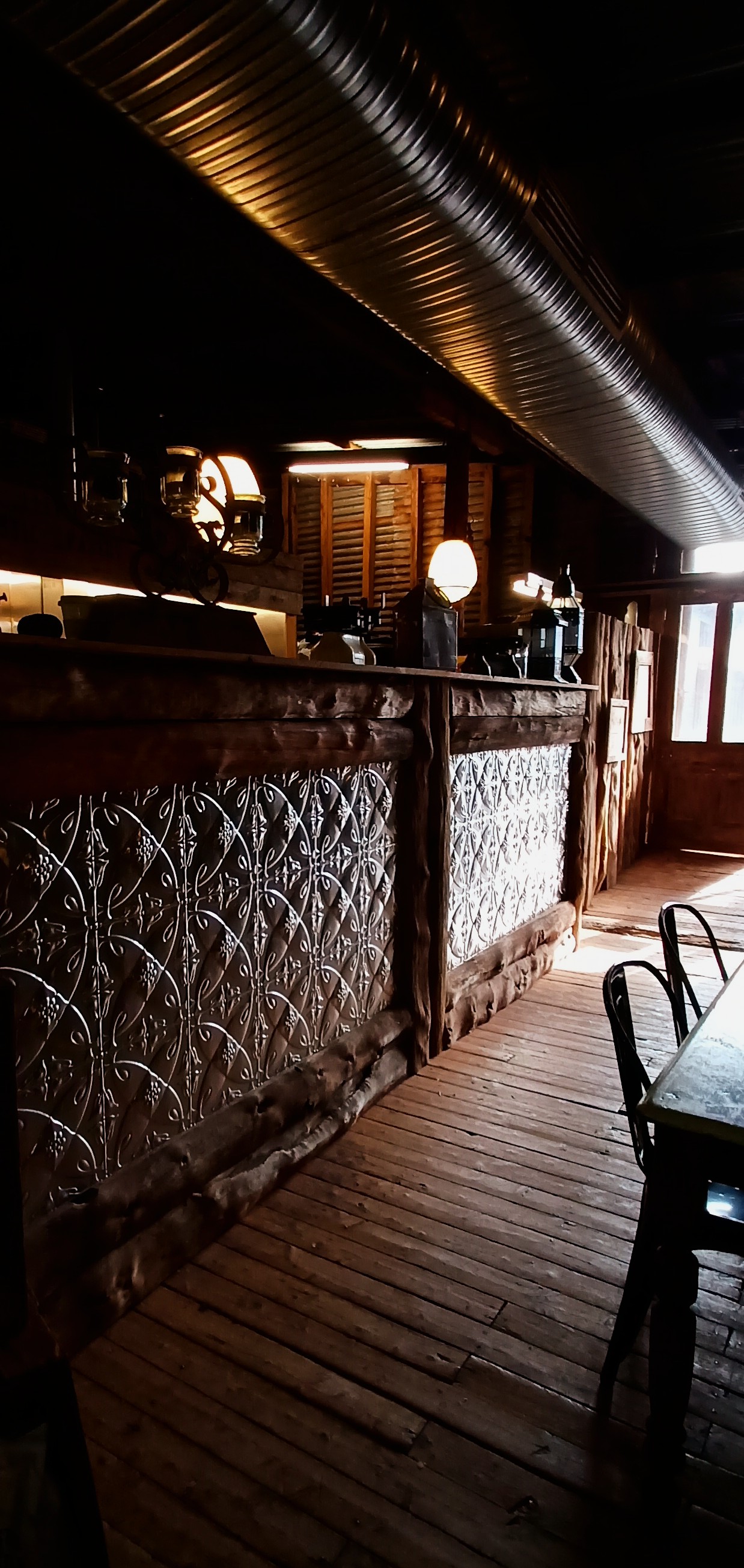 A lantern-lit corridor with pressed-metal panelling and timber shutters